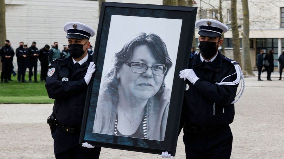 Полицейские Ренча держат портрет убитой Стефани Монферм, матери и сотрудника местной полиции, во время митинга в Рамбуйе, пригороде к юго-западу от Парижа, 30 апреля 2021 г.