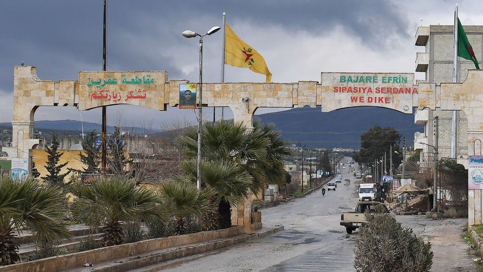 YPG flag flies from a mast near an entrance to the Kurdish-controlled city of Afrin, north-western Syria (25 January 2018)