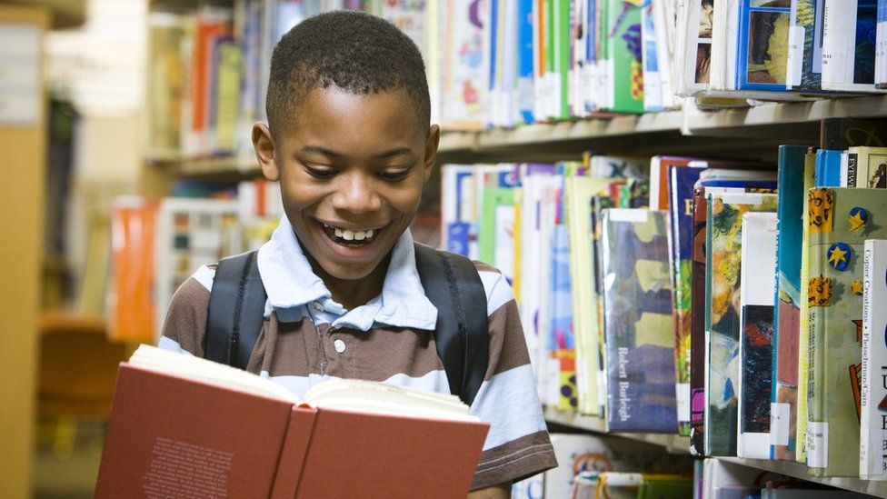 boy-smiling-and-holding-book.