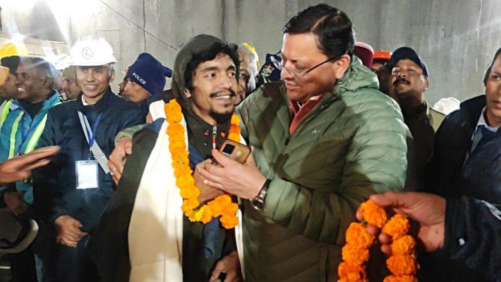 Uttarakhand Chief Minister Pushkar Singh Dhami (C) with the rescued worker inside the tunnel on the Brahmakal Yamunotri National Highway in Uttarkashi, India, 28 November 2023