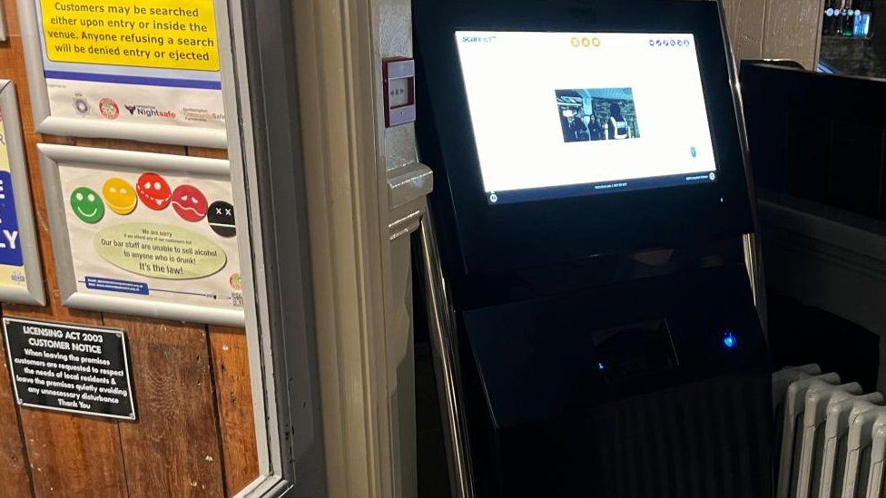 Scanning machine (fruit machine size) by a doorway in a nightclub