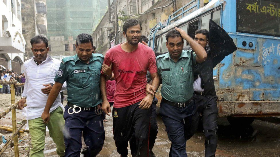 Bangladeshi cricketer Shahadat Hossain is taken away by policemen after he surrendered before a court in Dhaka, Bangladesh