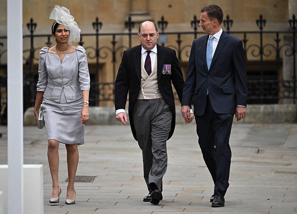 British Home Secretary Suella Braverman, Defence Secretary Ben Wallace and Chancellor of the Exchequer Jeremy Hunt walk outside Westminster Abbey
