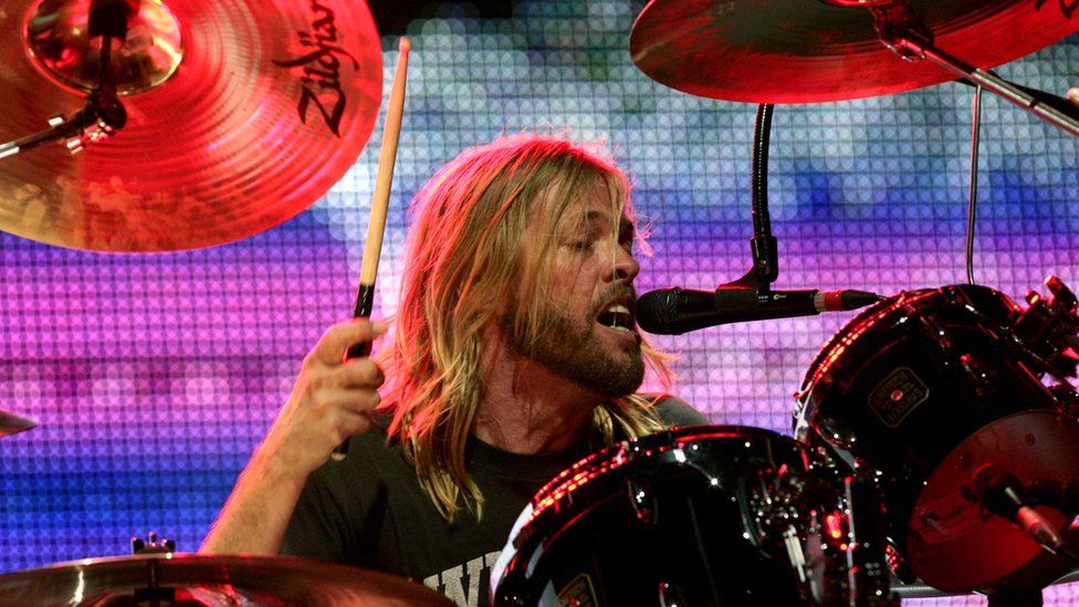 Taylor Hawkins plays the drums and sings into the microphone at a Foo Fighters gig