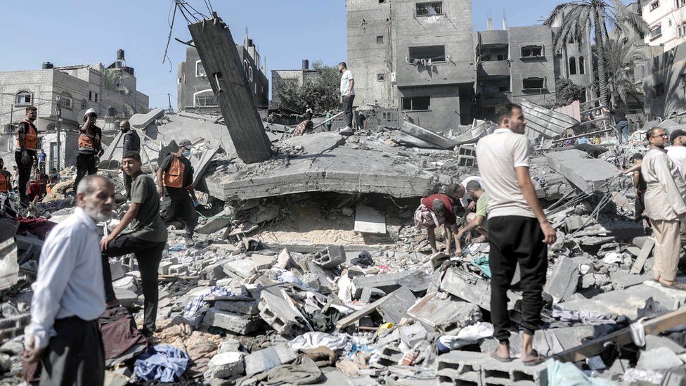 Palestinians search for victims and survivors in the rubble of a residential building levelled in an Israeli airstrike in Khan Younis refugee camp in the southern Gaza Strip.