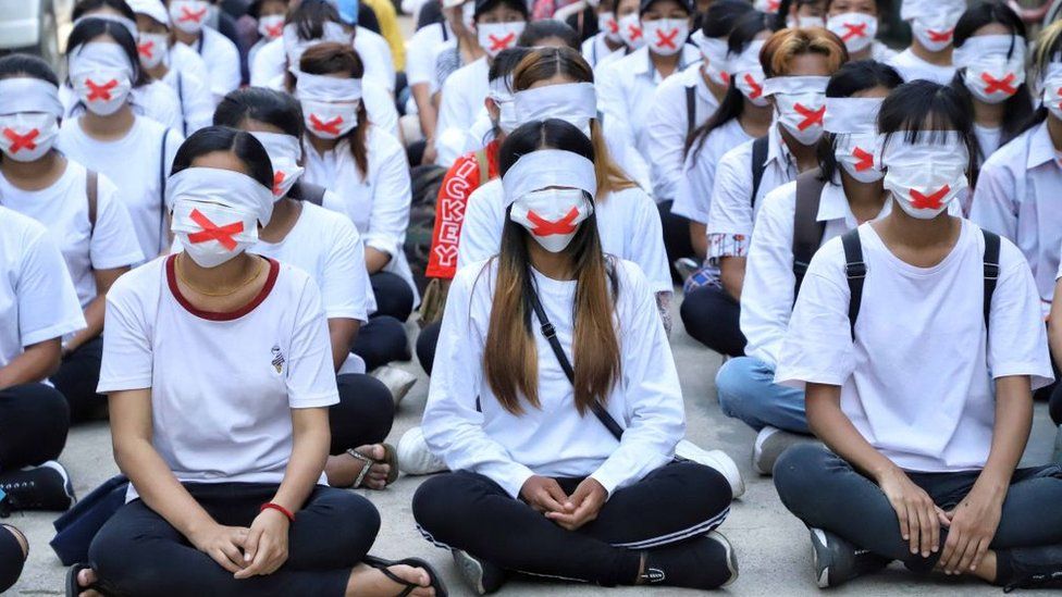 Протестующие с закрытыми ртами и глазами в «тихой забастовке» 24 марта 2021 года в знак протеста против расстрела военными семилетней девочки