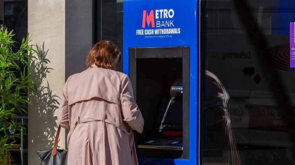 Woman using Metro Bank ATM