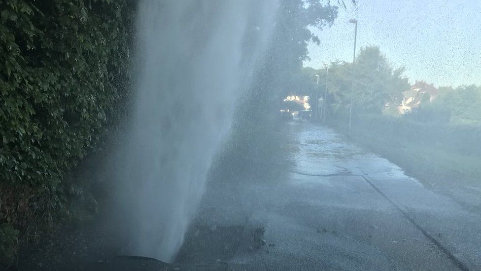 The burst main sending a fountain of water into the air