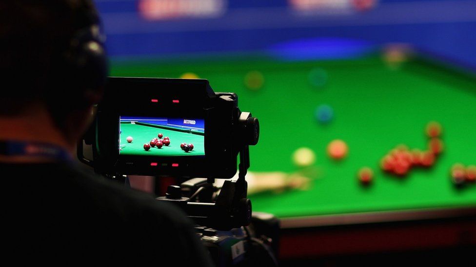 Cameraman filming snooker match