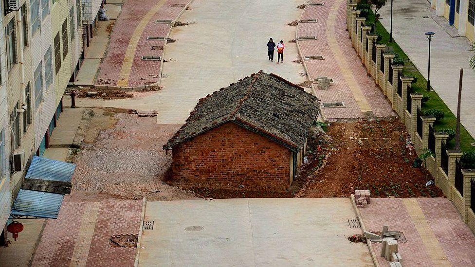 A 'nail' house blocks the road almost completely outside a residential block on April 10, 2015 in Nanning, South China.