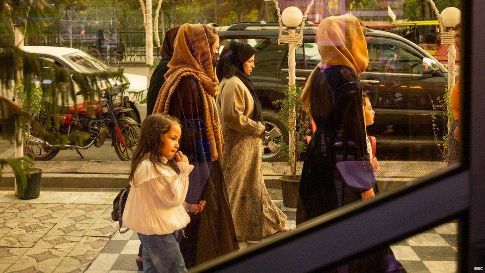 Группа женщин проходит мимо ресторана в Кабуле