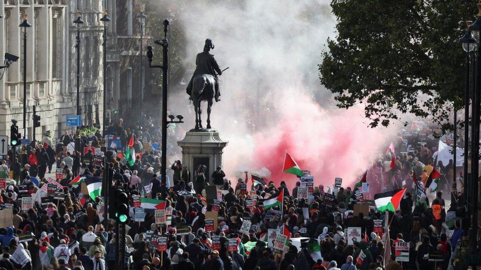 Demonstrators protest in solidarity with Palestinians in central London, flares have been set off and flags are being waves