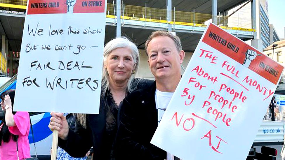 Writers Alice Nutter and Simon Beaufoy holding placards outside the Full Monty series premiere in Sheffield on 5 June