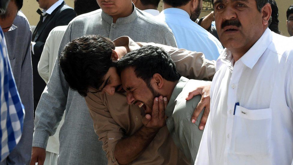 Pakistani local journalists react over the body of a news cameraman after a bomb explosion at a government hospital premises in Quetta on August 8, 2016.