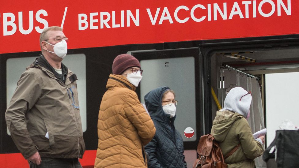People stand in front of a vaccination bus on 17 November 2021 in Berlin