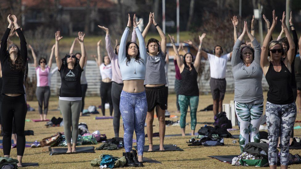 Women with arms raised practising yoga in Johannesburg, South Africa - Saturday 19 June 2021