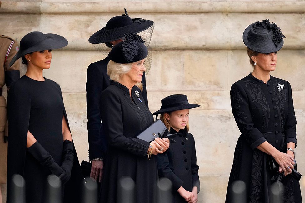 Meghan, Duchess of Sussex, Camilla, Queen Consort, Princess Charlotte of Wales and Sophie, Countess of Wessex watch on as The Queen's funeral cortege borne on the State Gun Carriage of the Royal Navy as it departs Westminster Abbey on September 19, 2022 in London
