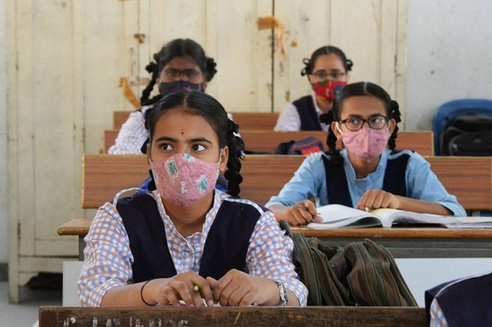 Студенты в масках поддерживают социальную дистанцию, посещая занятия в государственной средней школе для девочек на фоне продолжающейся пандемии коронавируса Covid-19 в Хайдарабаде 17 марта 2021 года.