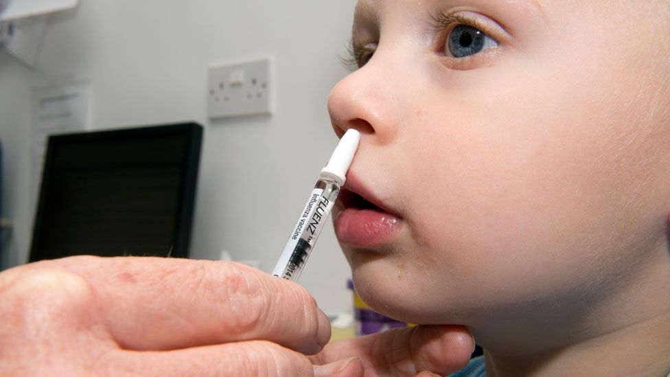A young boy receiving the nasal-spray flu vaccine