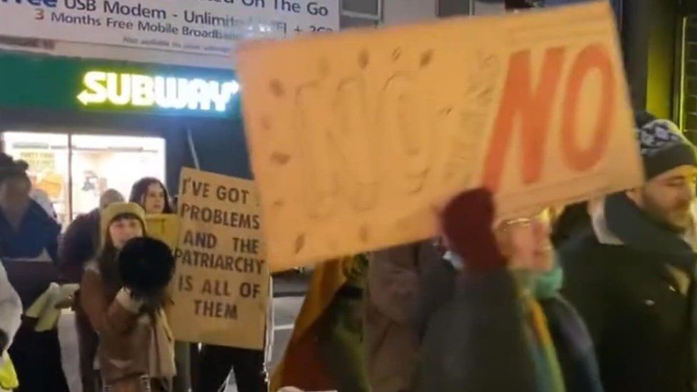 Women with placards marching through Northampton town centre during the evening