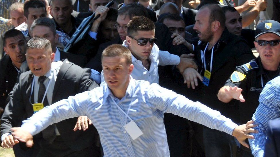 Bodyguards try to protect Serbian Prime Minister Aleksandar Vucic at commemorations of the Srebrenica massacre