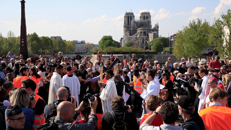 People attend a procession close to Notre-Dame
