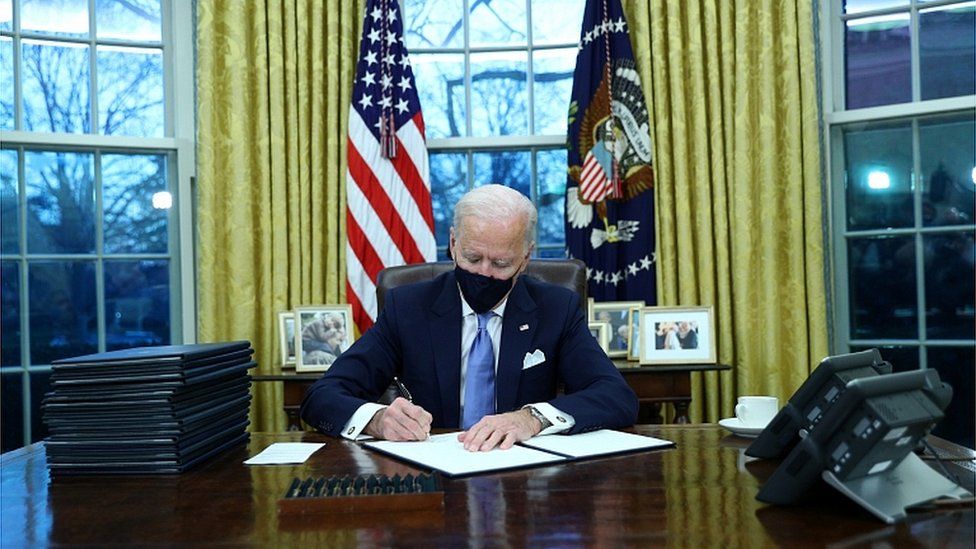 Президент США Джо Байден подписывает документы после принесения присяги