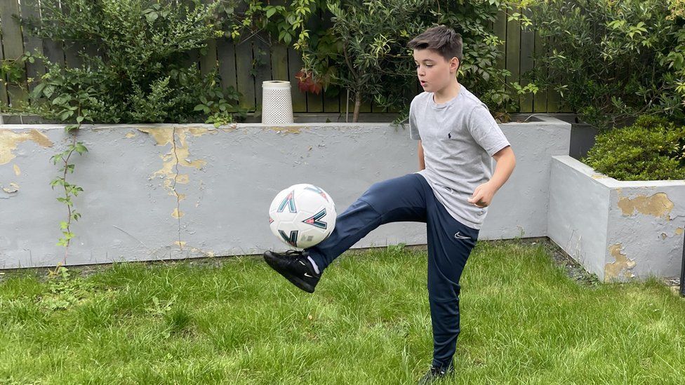 Elliott playing football in the garden