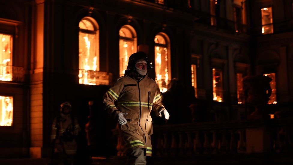 A firefighter walks in front of the National Museum of Rio de Janeiro, one of the oldest in Brazil, as it is consumed by flames due to a major fire, in Rio de Janeiro, Brazil, 2 September 2018.