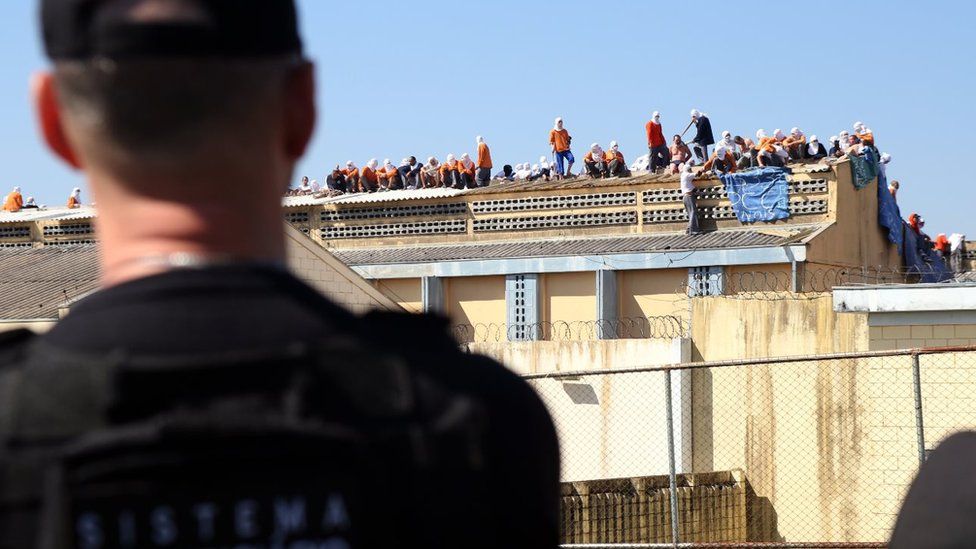 Inmates stand on the roof of the penitentiary in Cascavel, Parana state, Brazil, during a riot