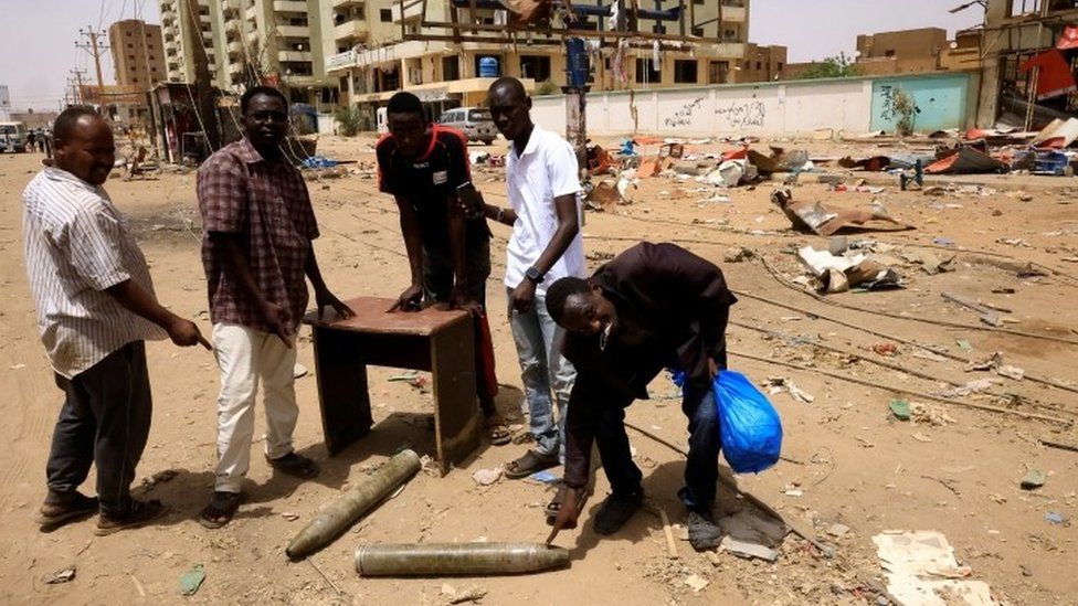 People look at shells on the ground in northern Khartoum