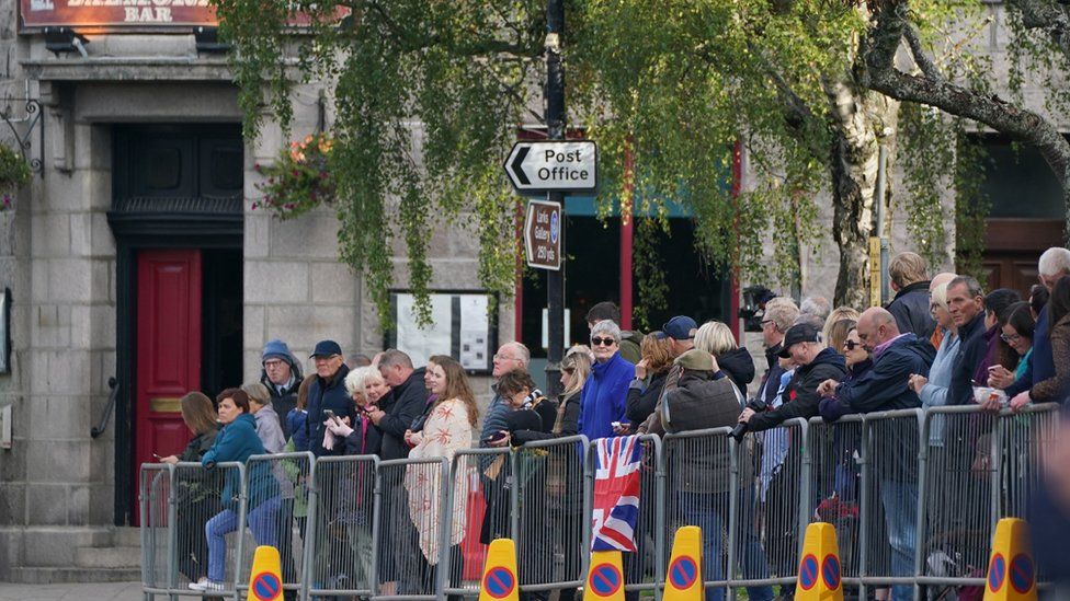 Members of the public line the streets in Ballater, Scotland, as the hearse carrying the coffin of Queen Elizabeth II, will pass through Ballater