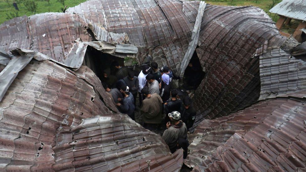 Kashmri people inspect a damaged house where militant commander Zakir Musa was killed at Dadsara village in Tral, south of Srinagar, the summer capital of Indian Kashmir, 24 May 2019.