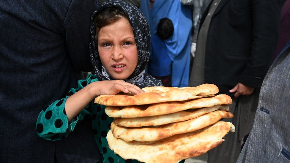 A young girl receives free bread from the municipality during Ramadan as the government-imposed a nationwide lockdown, in Kabul on April 29, 2020