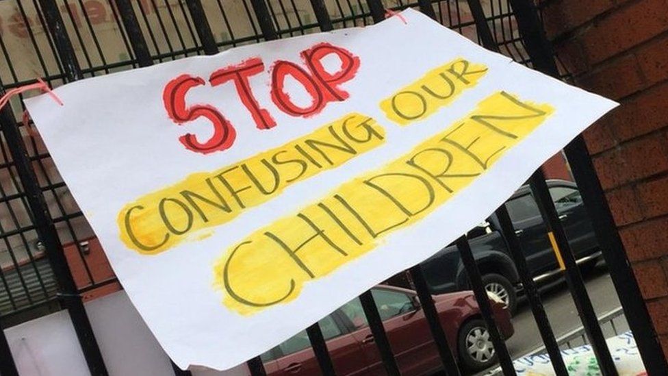 A 'Stop confusing our children' sign on the iron railings outside the school