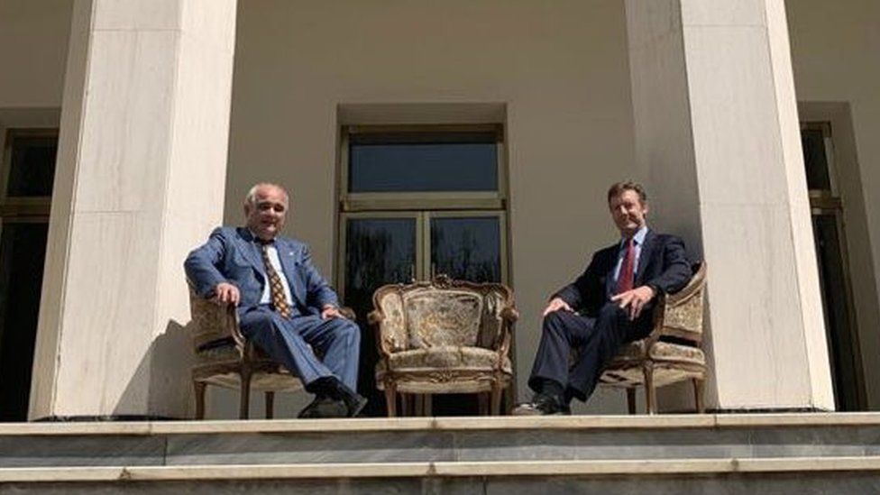 Russian and British ambassadors pose in chairs