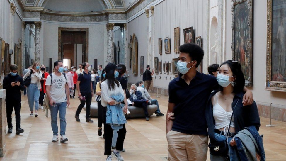 People walk around the newly reopened Louvre in Paris