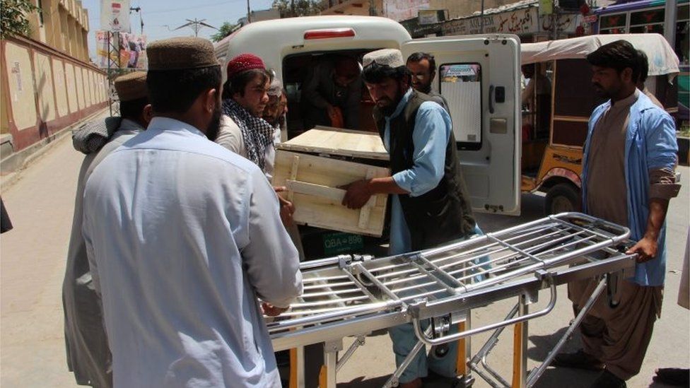 People shift a coffin containing body of one of the two people killed in a US drone in Noshki, and one of the said to be of Taliban leader Mullah Akhtar Mansoor, after the bodies were brought to a hospital in Quetta, Pakistan, 22 May 2016.