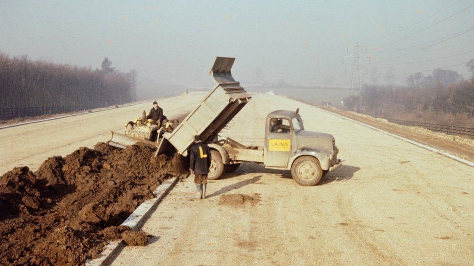 A lorry dumps soil for the central reservation