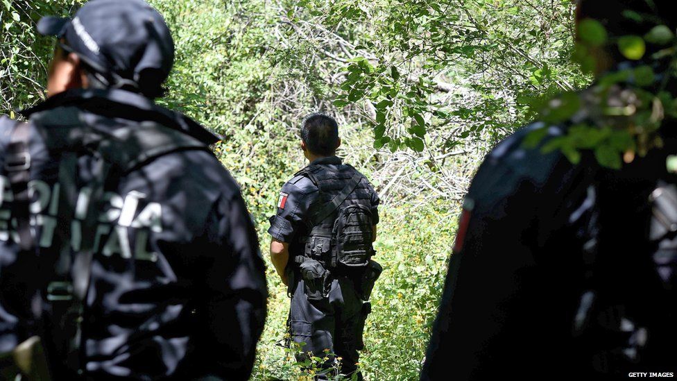 Police guard a mass grave outside Iguala. 9 Oct 2014