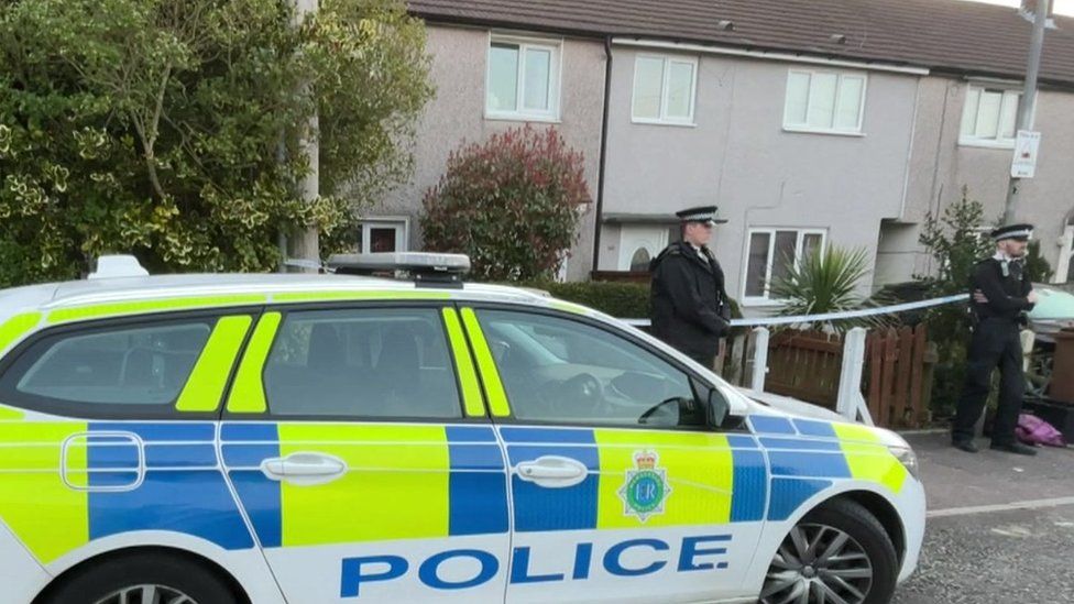 Police car outside house with two police officers