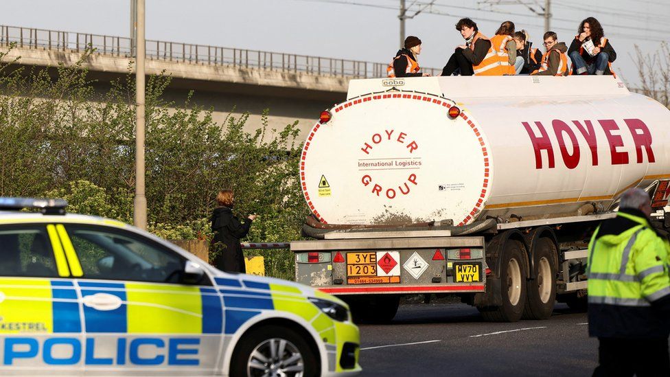 Activists from Just Stop Oil block an entrance to a fuel terminal during a protest in Grays.