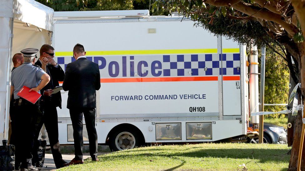 Police are seen at a property in Bedford, Perth after a group of people were found dead