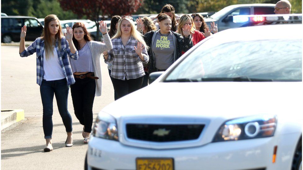 Students, staff and faculty are evacuated from Umpqua Community College in Roseburg, Ore. on 1 October 2015, after a deadly shooting.