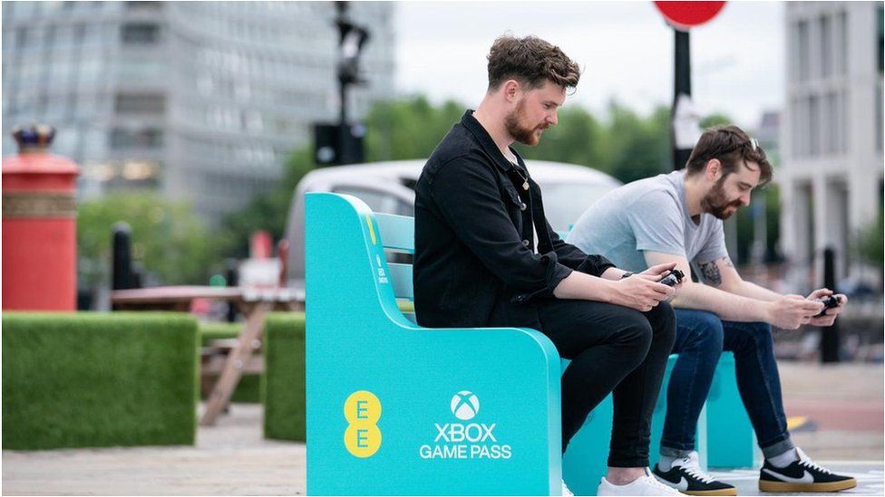 Phone users on an EE bench