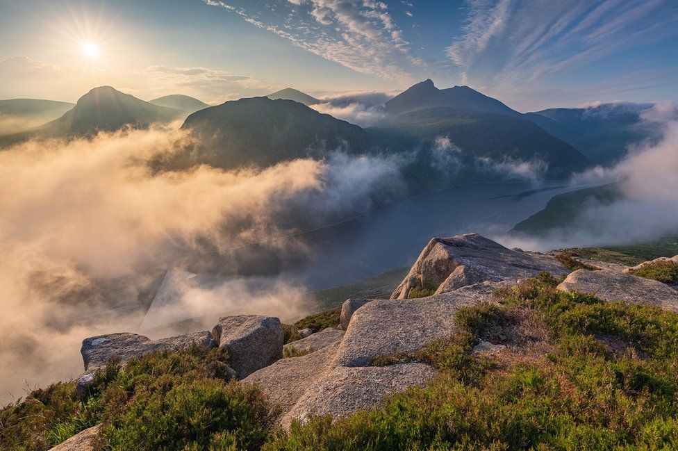 Sunrise over Ben Crom reservoir and peaks in the Mourne mountains in County Down as seen from the top of Slieve Binnian