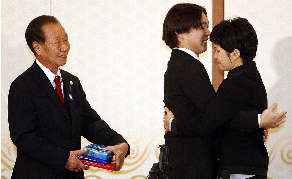 Shigeo Iizuka looks on as Koichiro Iizuka, son of the abductee Yaeko Taguchi, hugs former North Korean spy Kim Hyun-hui before a press conference on March 11, 2009 in Busan, South Korea.