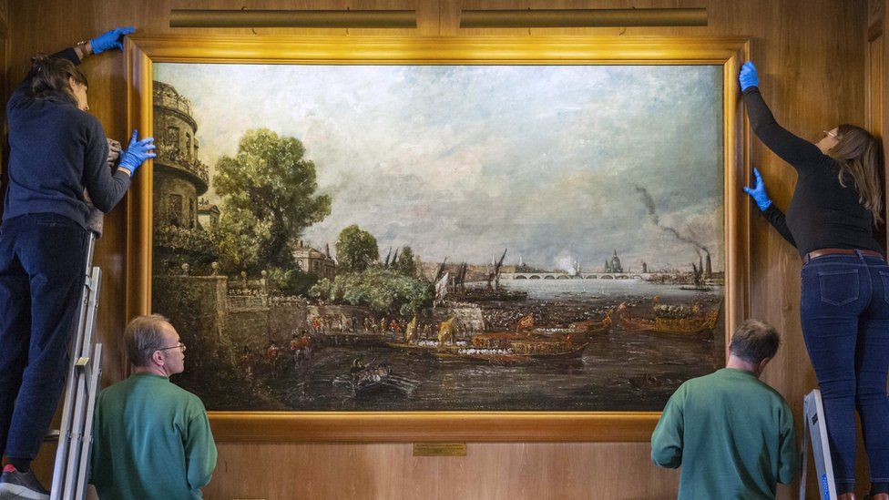 A painting, The Embarkation of George IV from Whitehall: the Opening of Waterloo Bridge, 1817, being hung at Anglesey Abbey in Cambridgeshire