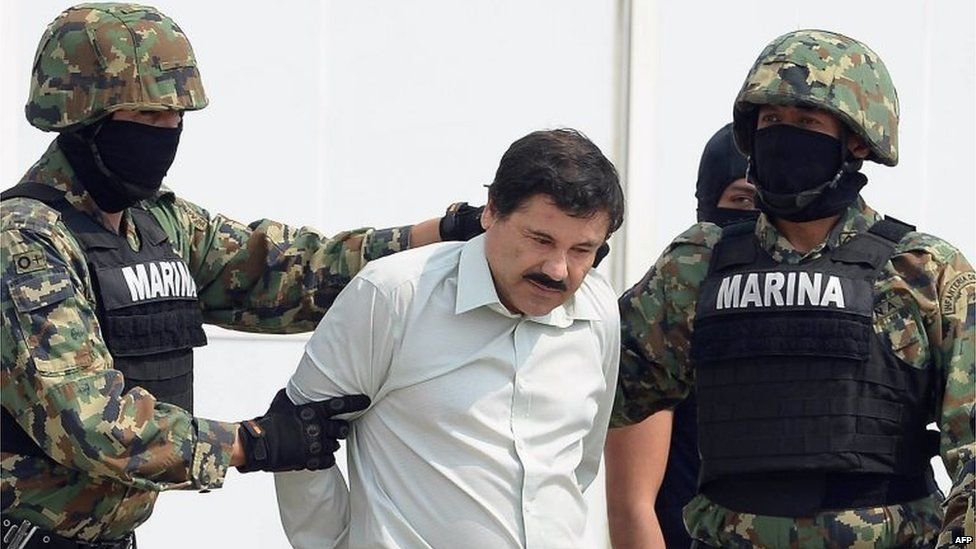 Mexican drug trafficker Joaquin Guzman Loera is escorted by marines as he is presented to the press on 22 February, 2014 in Mexico City.