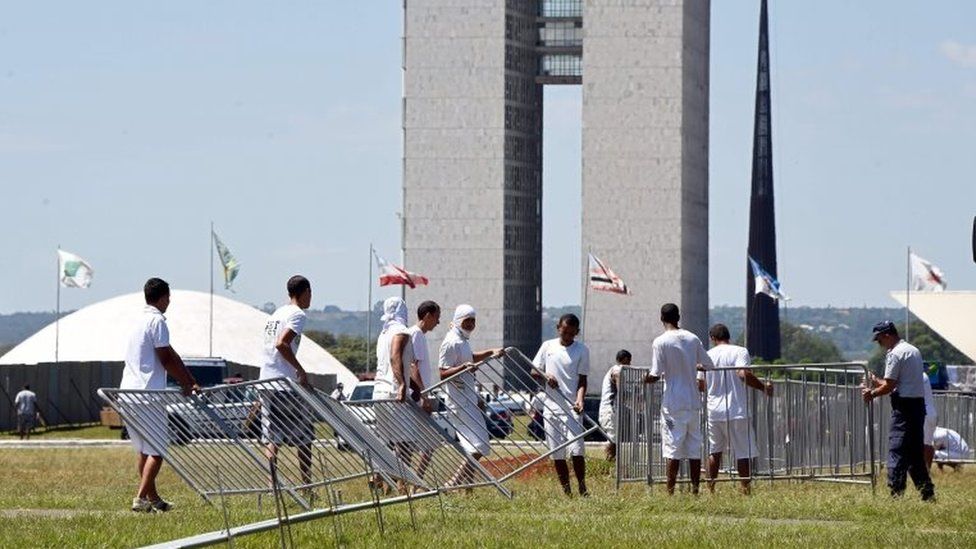 Prisoners from the Provisional Detention Center set up a security fence to separate the demonstrators against and supporting the impeachment of President Dilma Rousseff, in front of the Congress in the Esplanada dos Ministerios in Brasilia, on April 10, 2016.